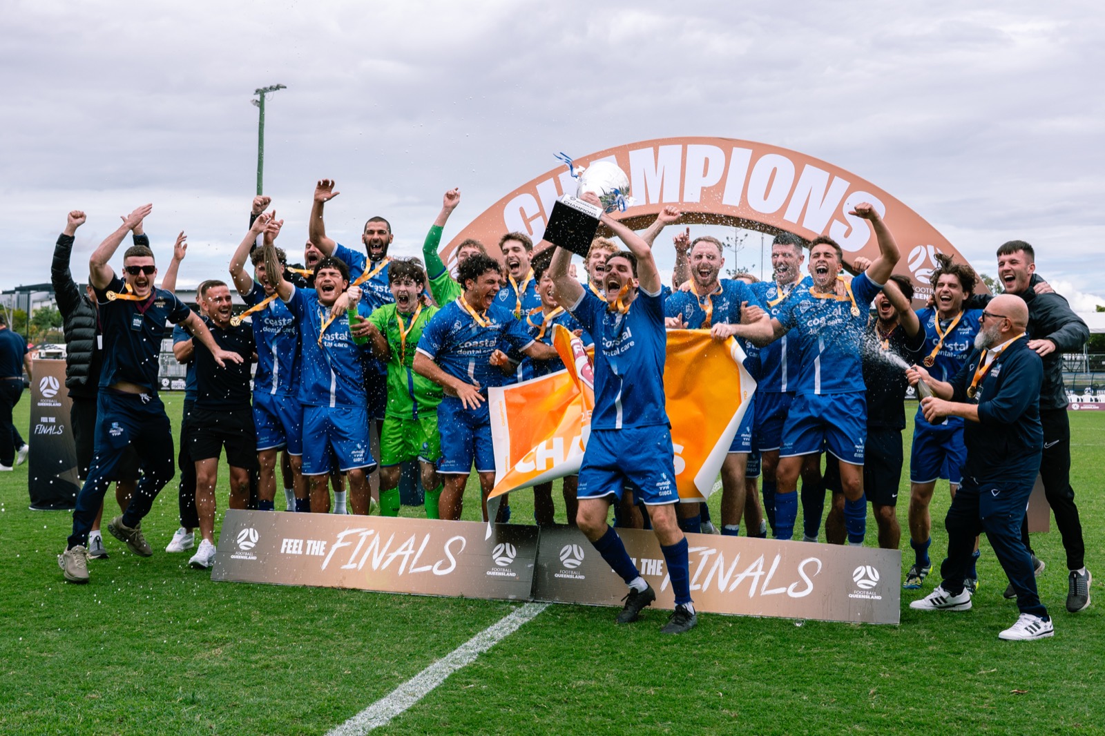 Football team lifting the championship trophy during grand final celebrations